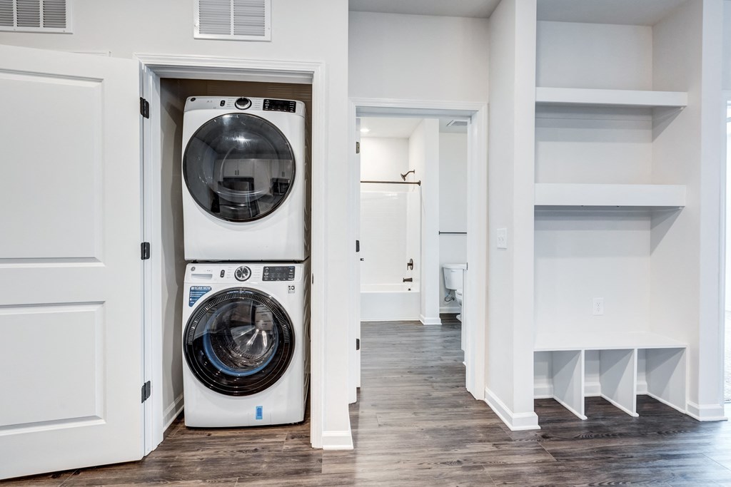 a white washer and dryer in a room with white walls and a door