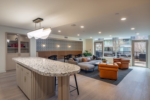 A modern kitchen with a curved island and a dining area with a table and chairs.