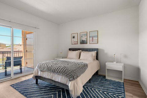 A bedroom with a large bed and a view of the outside.