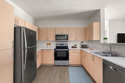 A kitchen with a black refrigerator, black microwave, black oven, and black dishwasher.