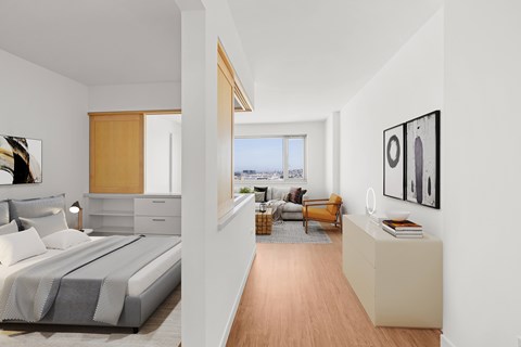 A bedroom with a large bed and a balcony overlooking the city.