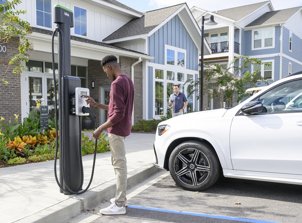 a man is charging his car at a gas pump