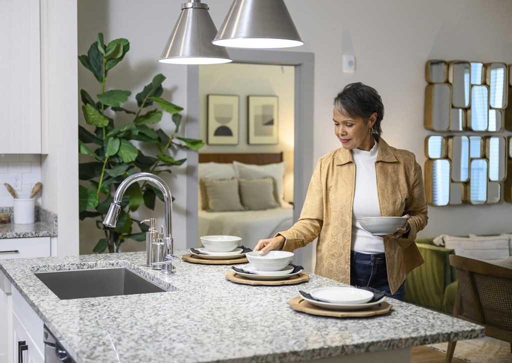 a woman placing dishes on a counter in a kitchen