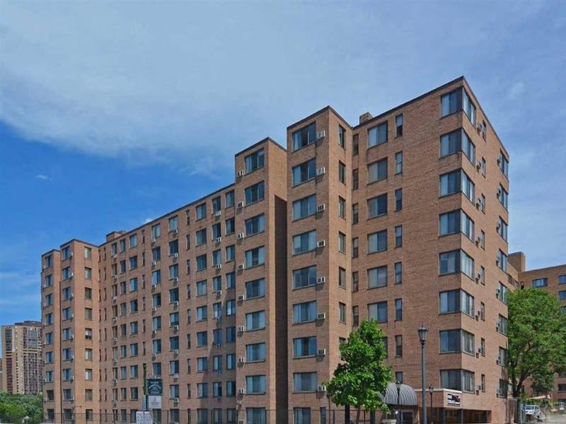 a large apartment building with a blue sky in the background