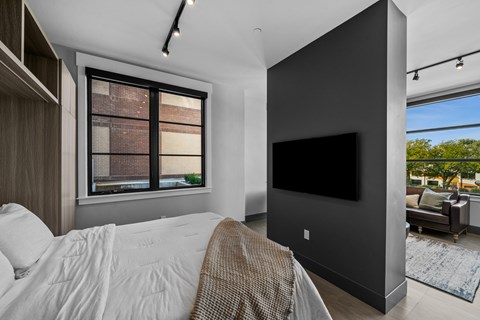 A modern bedroom with a large bed and a flat screen TV.
