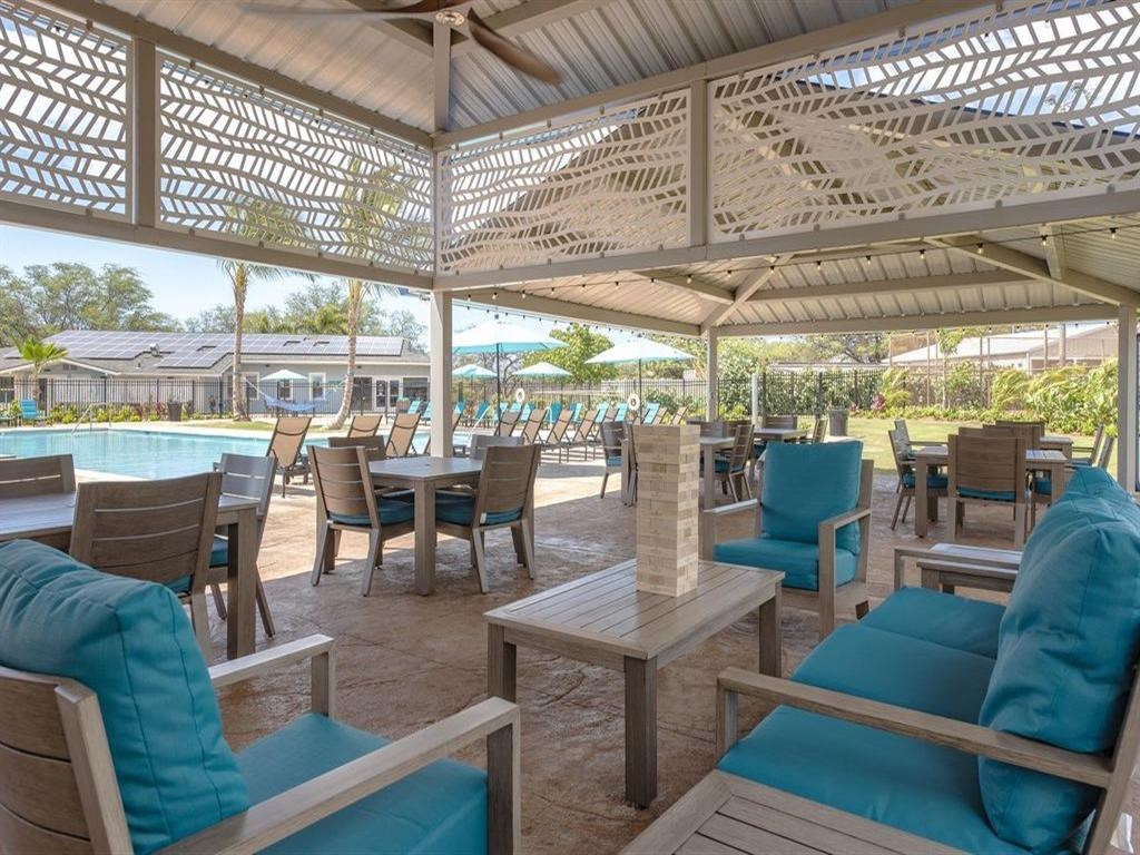 a patio with tables and chairs and a swimming pool