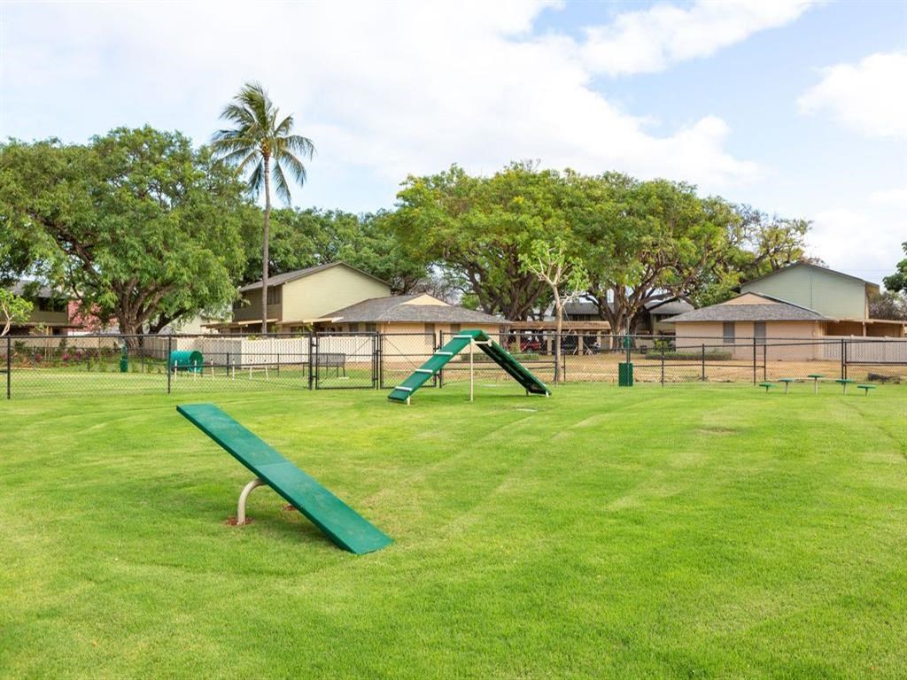 a park with a slide and a bench in the grass