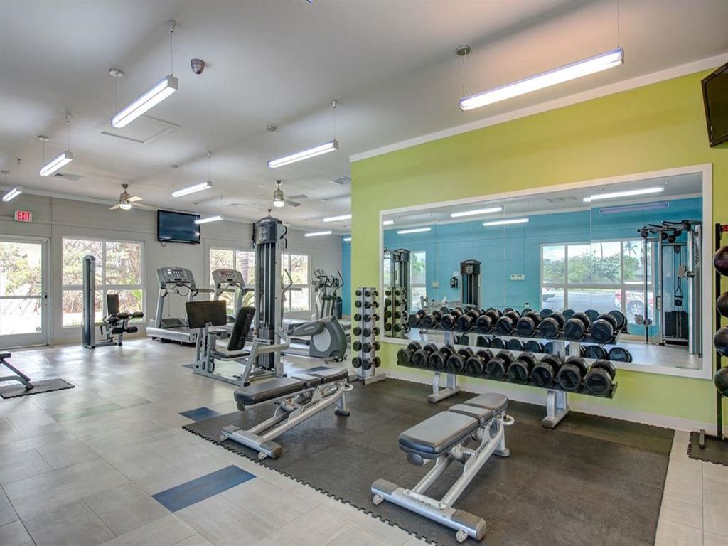 a gym with weights and cardio equipment at the apartments for rent