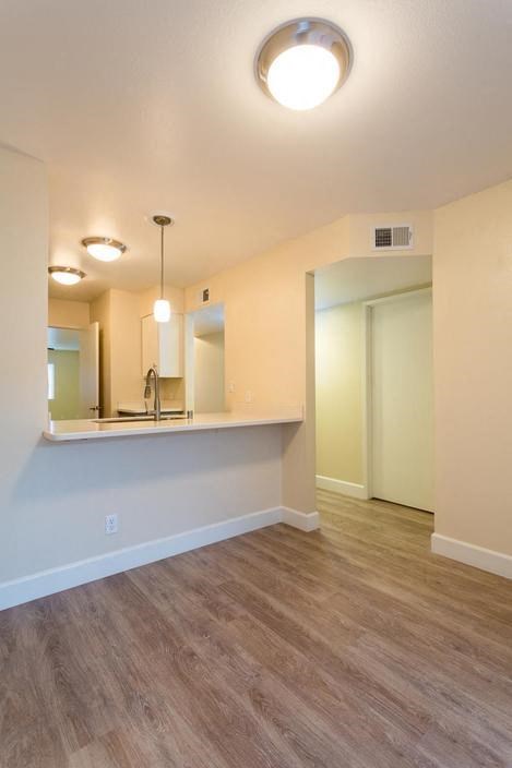 an empty living room and kitchen with a counter top