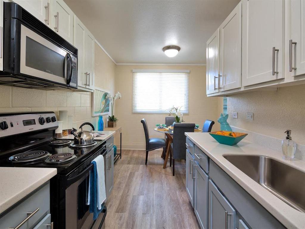 a kitchen with a stove and a sink and a microwave