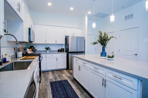 A modern kitchen with white cabinets and a dark countertop.
