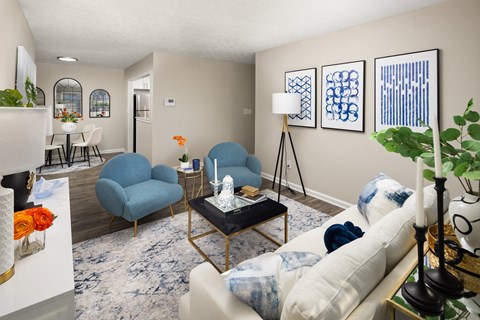A living room with a blue chair and a white couch.