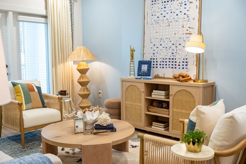 A living room with a wooden chair, a table with a vase, and a bookshelf.