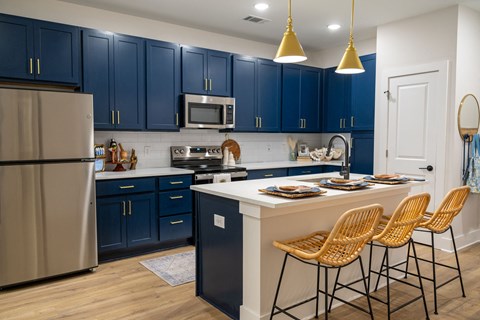 A kitchen with blue cabinets and a white island.