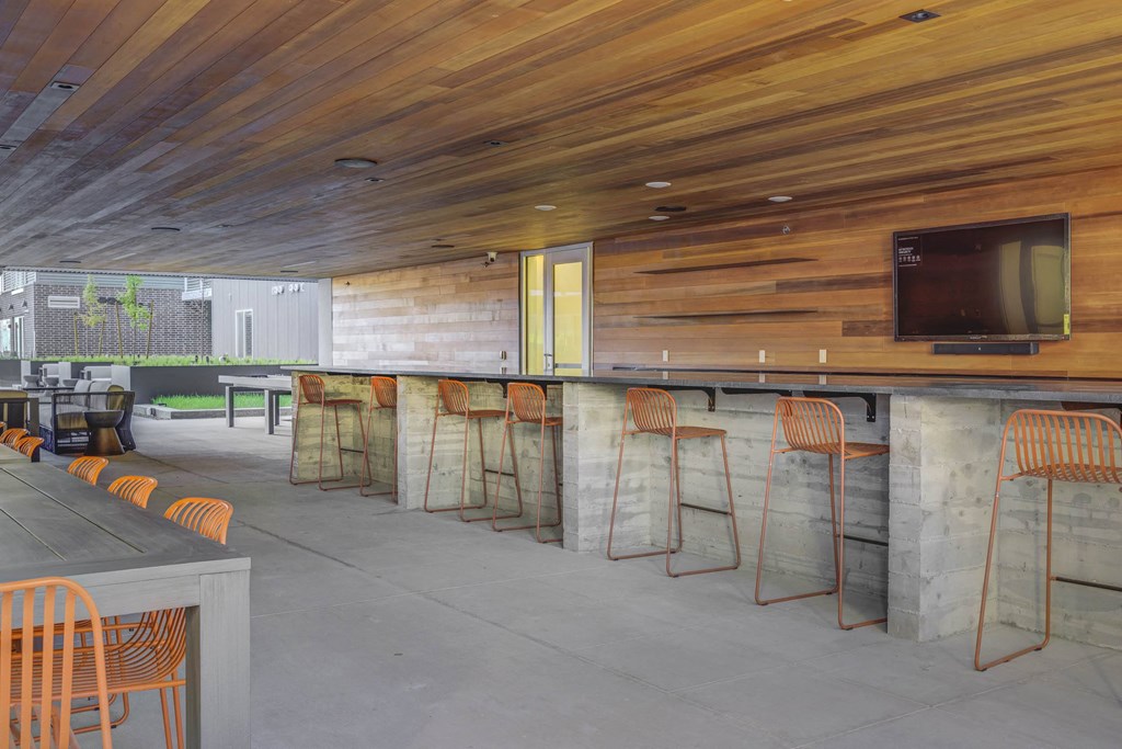 a bar with stools and a television on the wall