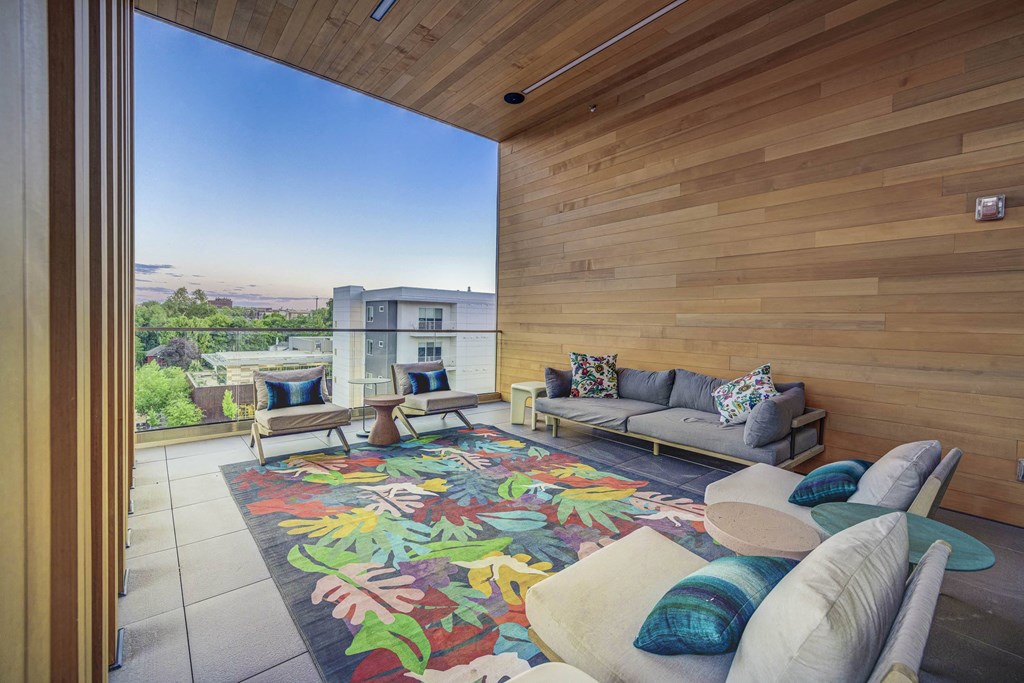 a living room with wooden walls and a colorful rug