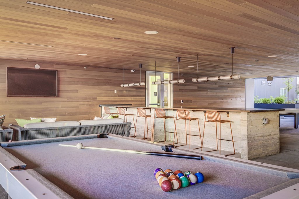 a game room with a pool table and bar