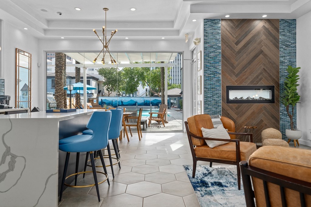 a lobby with a bar and a pool in the background