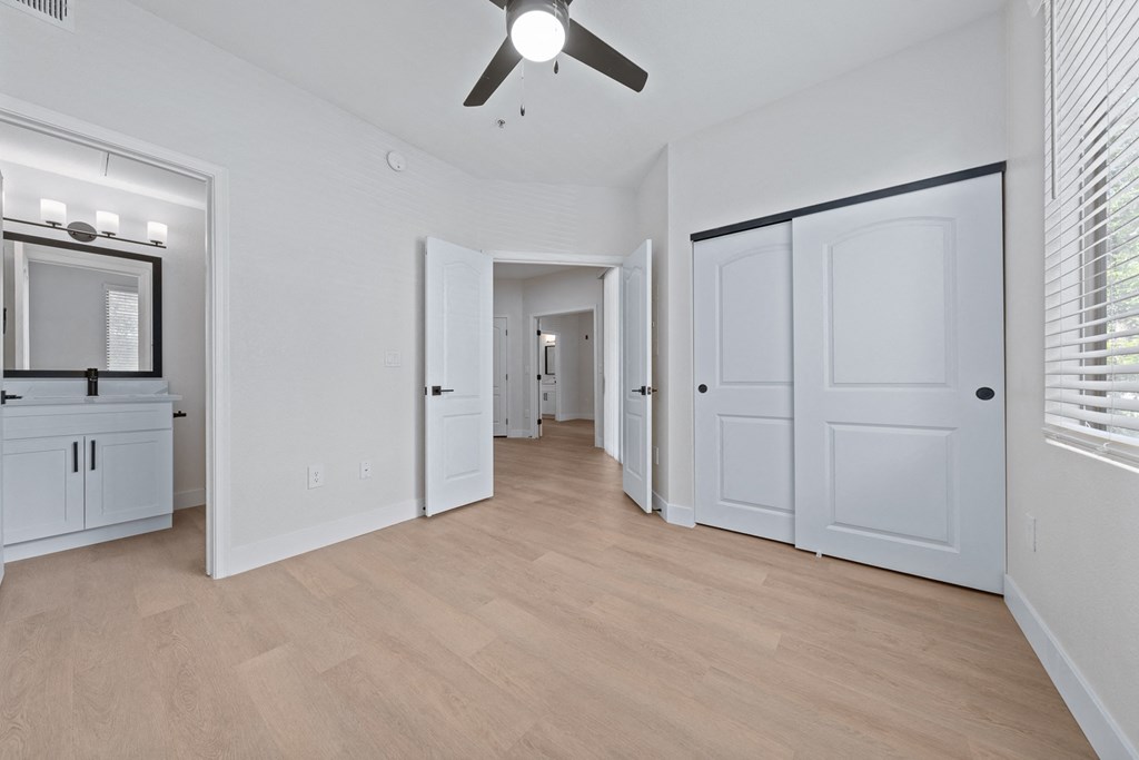 a bedroom with two closets and a ceiling fan