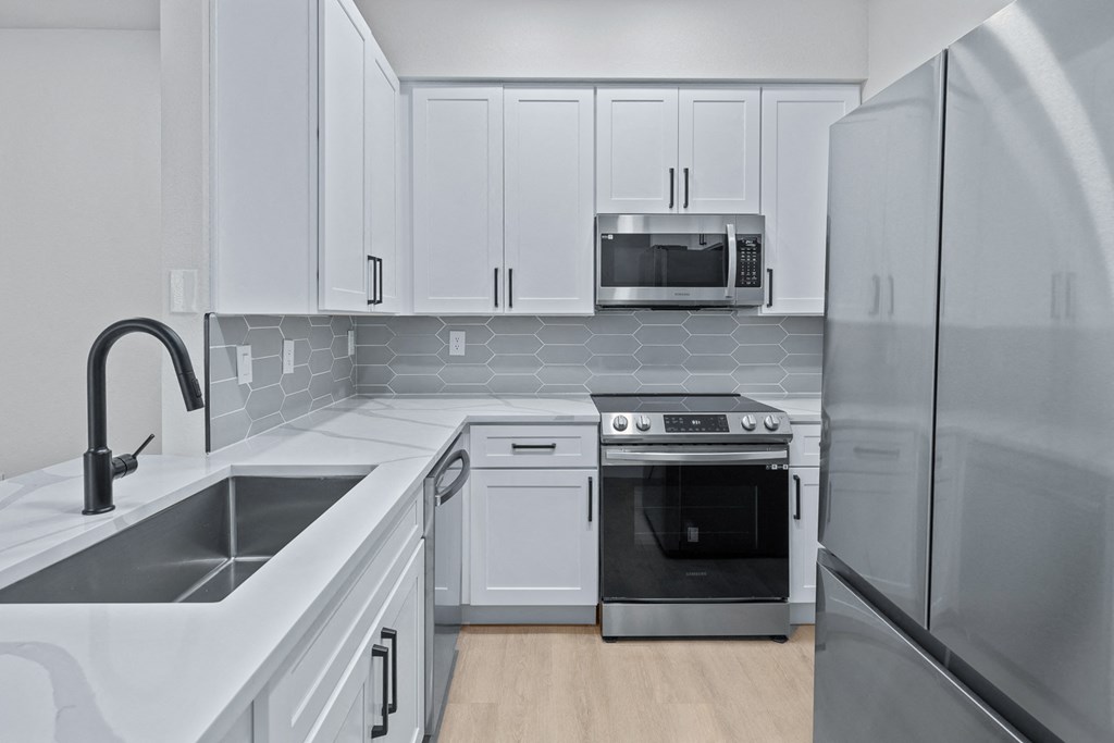 a kitchen with white cabinets and stainless steel appliances