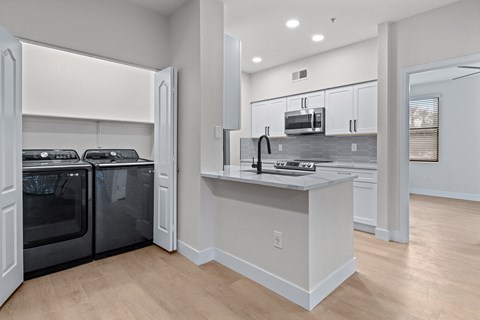 a kitchen with white cabinets and a counter top with a stove and a dishwasher