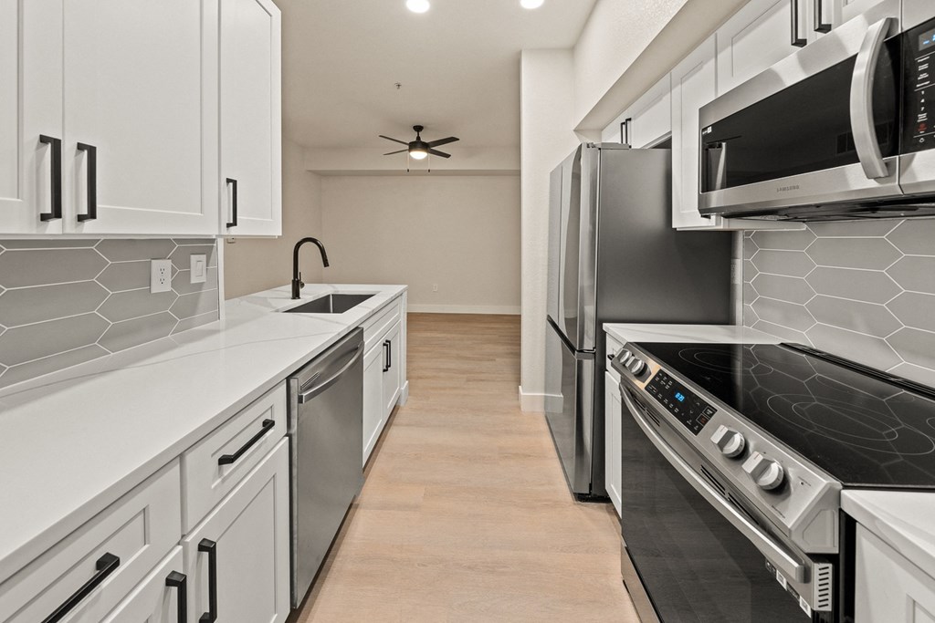 a kitchen with white cabinets and stainless steel appliances