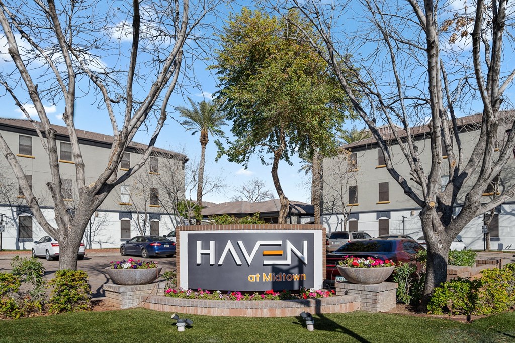 a large sign in front of a building with trees