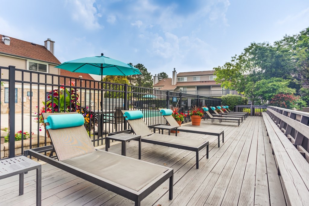 A sunny day at the pool with lounge chairs and umbrellas.