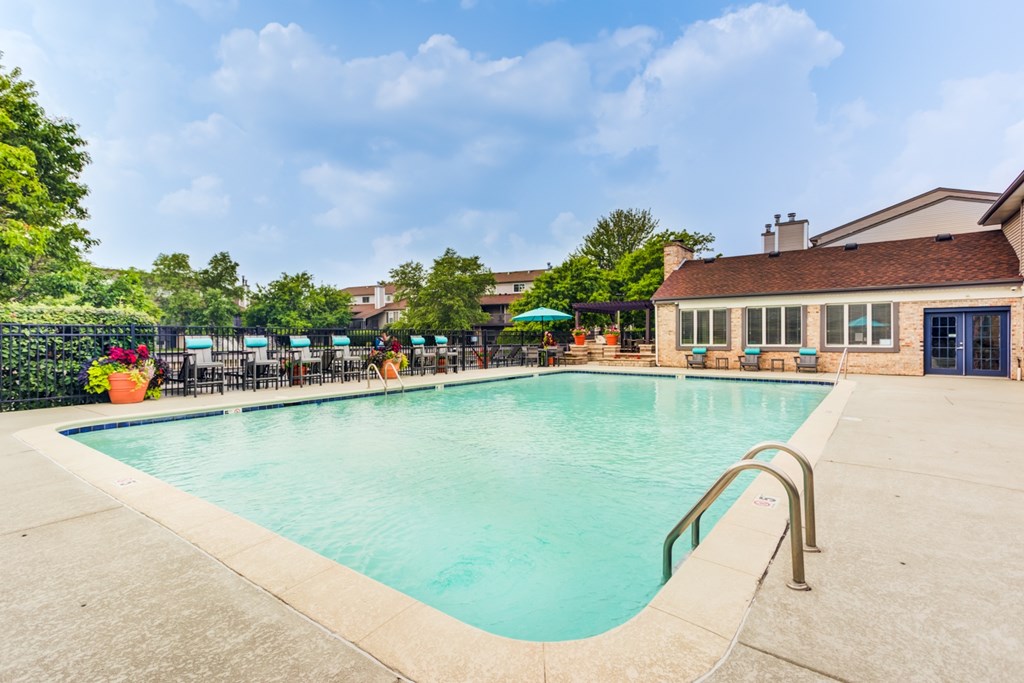 A large outdoor swimming pool with a metal ladder on the side.
