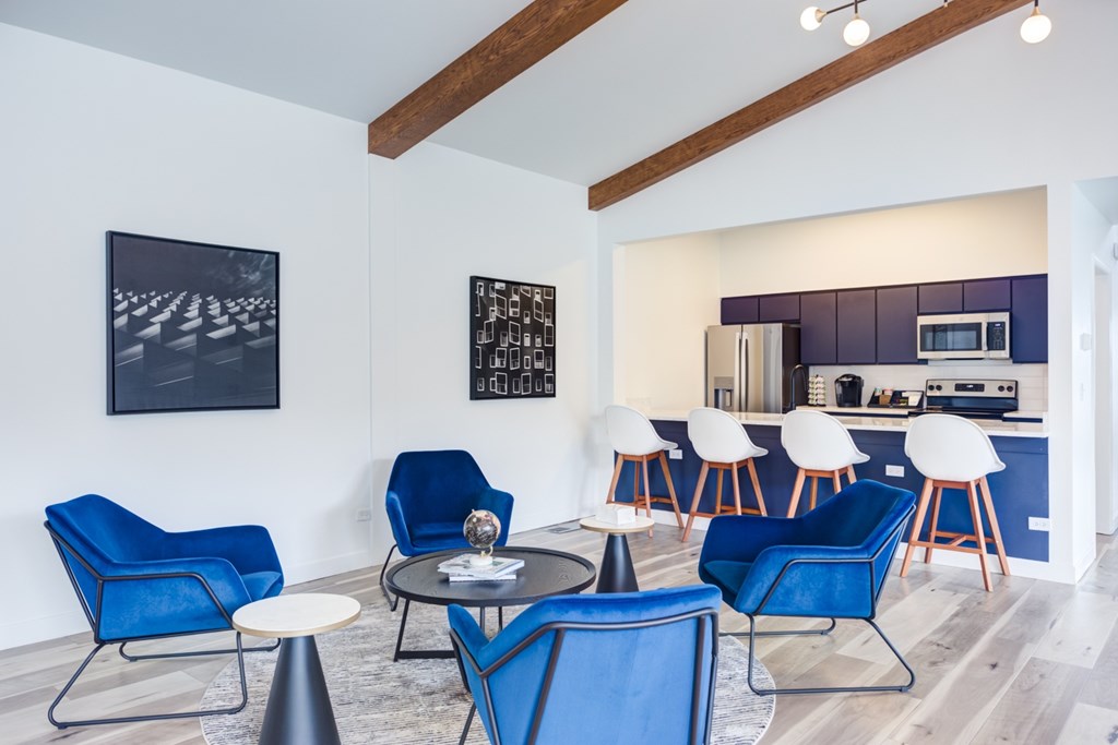 A modern living room with blue chairs and a dining table.