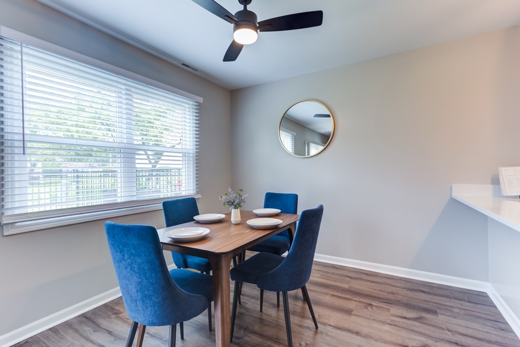 A dining room with a table set for four.