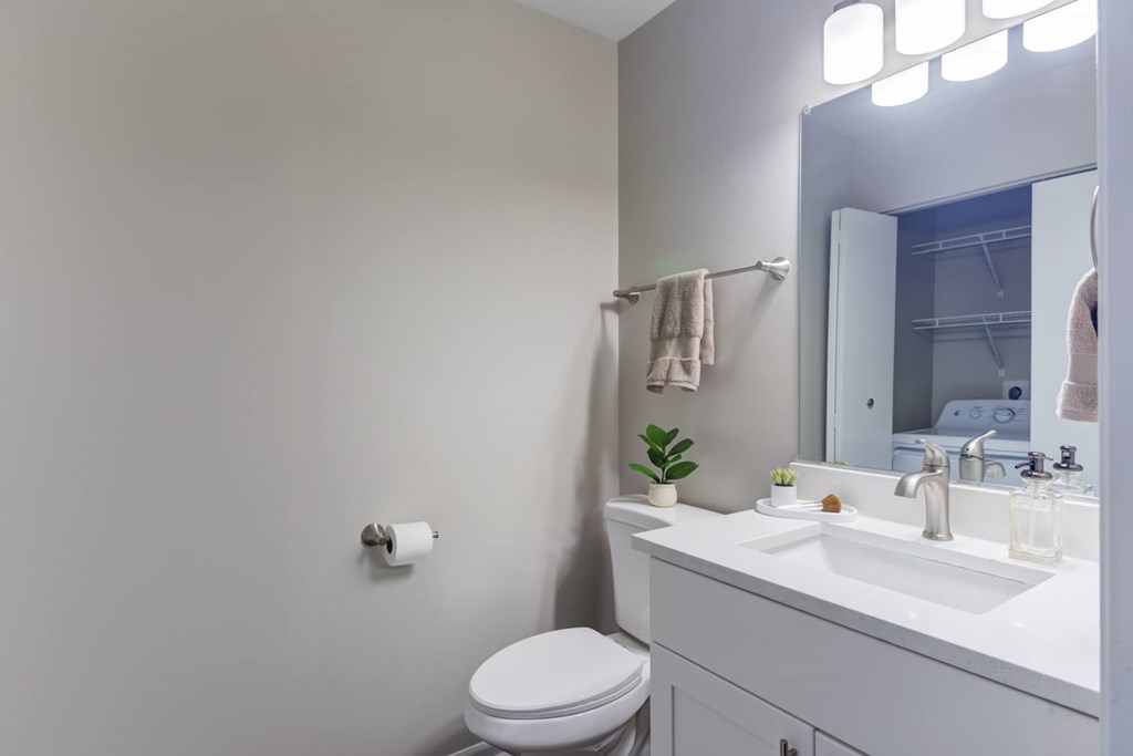 A white toilet is next to a white sink in a bathroom.