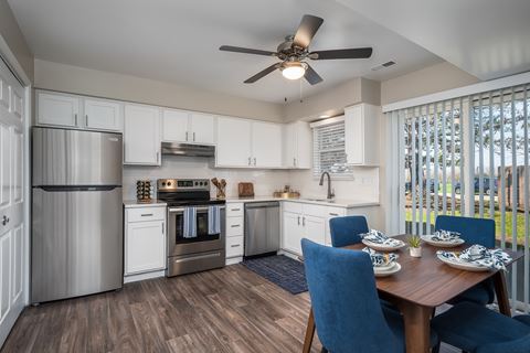 a kitchen and dining room with stainless steel appliances and a ceiling fan