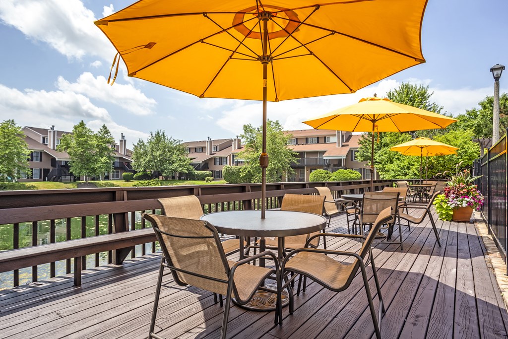 a patio with tables and umbrellas on a deck