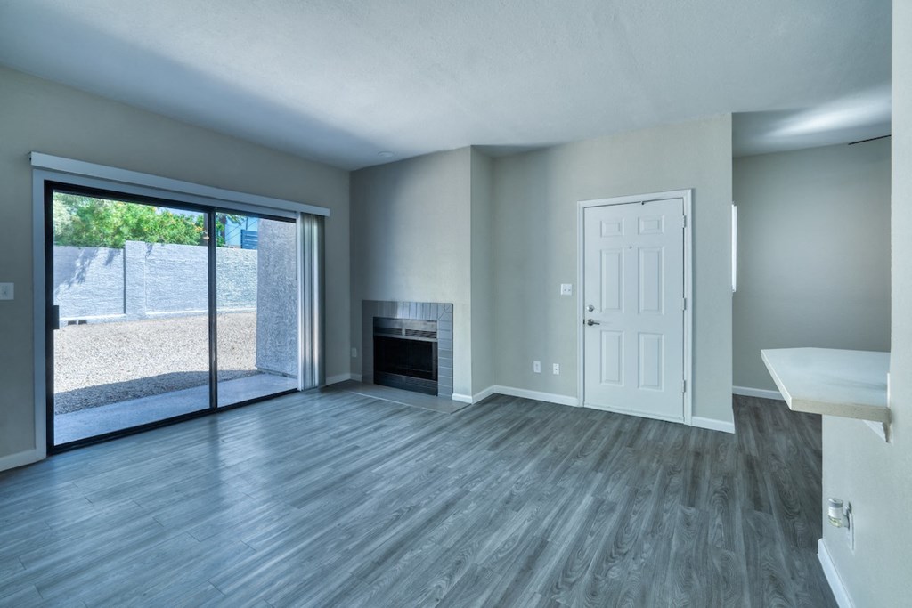 an empty living room with a fireplace and sliding glass door