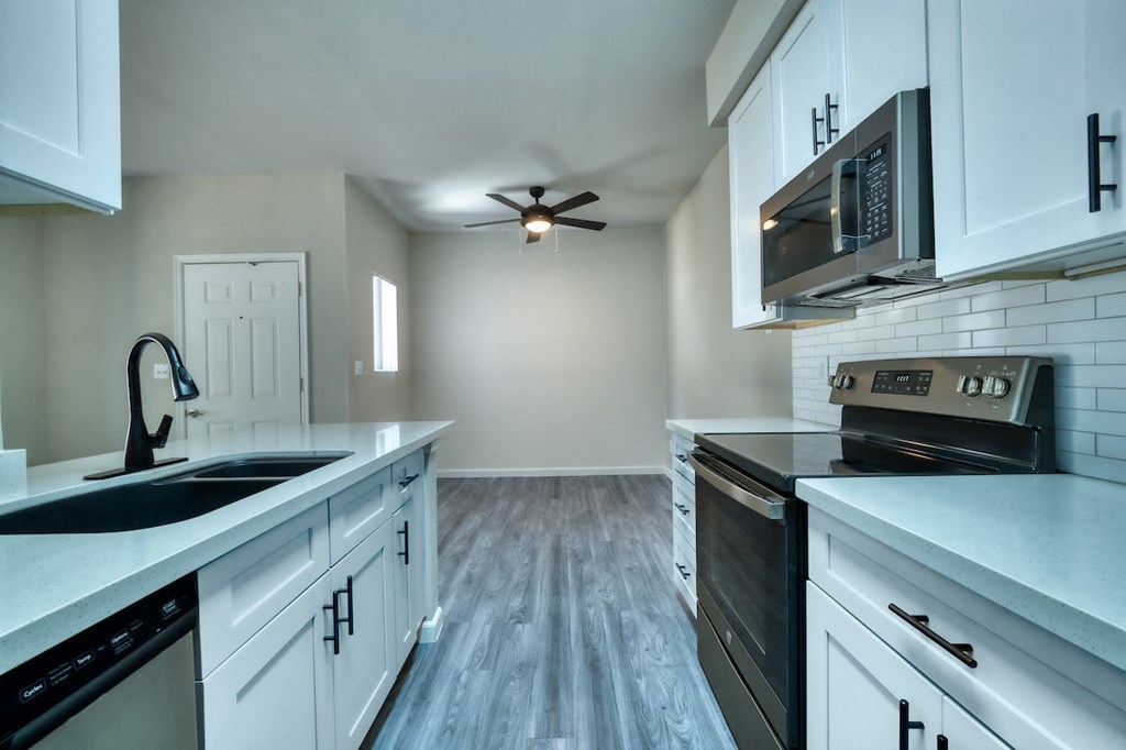 a kitchen with white cabinets and black appliances