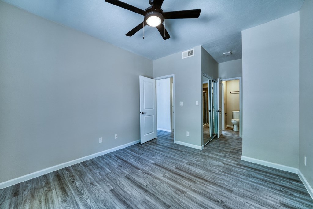 an empty living room with a ceiling fan