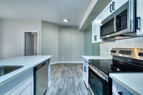 a renovated kitchen with white cabinets and stainless steel appliances