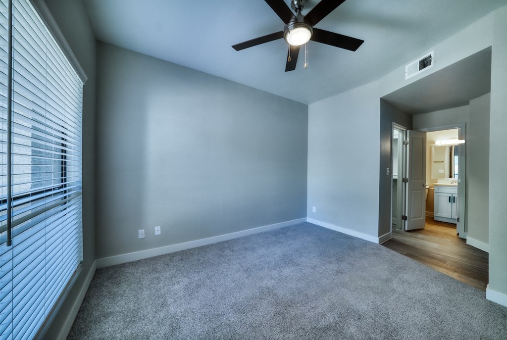 a bedroom with blue walls and a ceiling fan