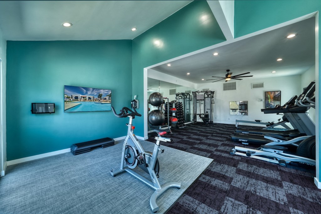 a home gym with a blue wall and a bike in the middle of the room