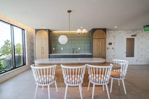A entertainment kitchen with a table and chairs.