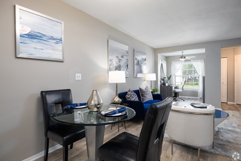 A modern dining room with a glass table and chairs.