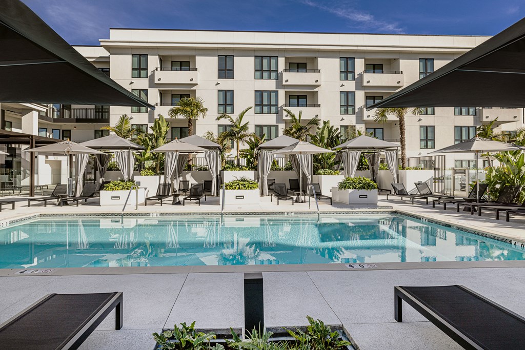a swimming pool with umbrellas and a building in the background