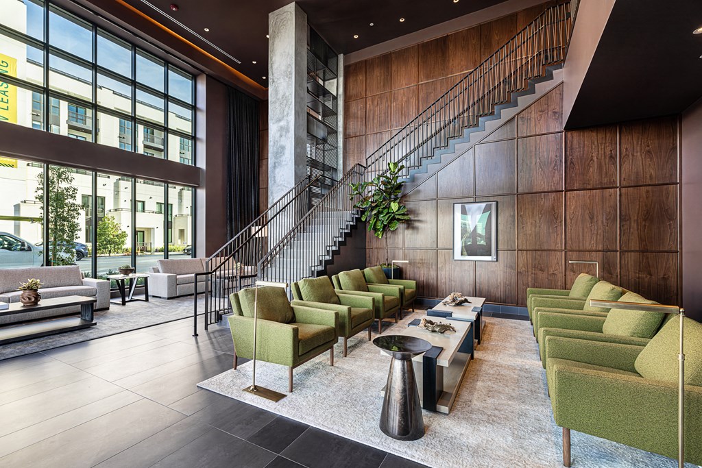 the lobby of a hotel with couches and chairs and a staircase