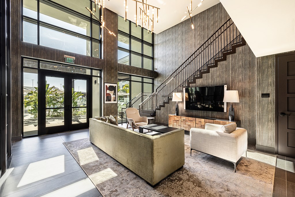 a living room with a couch and a tv and a staircase