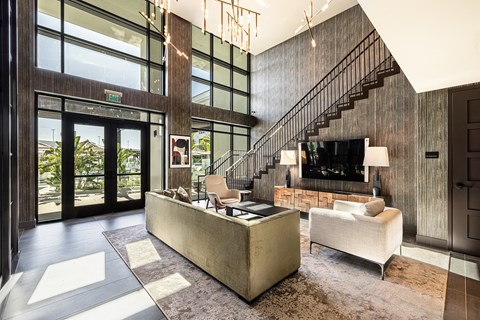 a living room with a couch and a tv and a staircase