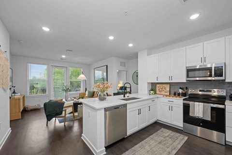 A modern kitchen with white cabinets and stainless steel appliances.