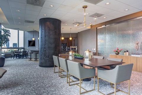 A dining room with a large table and chairs.