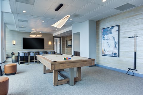 A room with a pool table and a television.