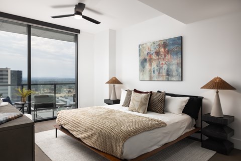 A bedroom with a large bed and a painting on the wall.